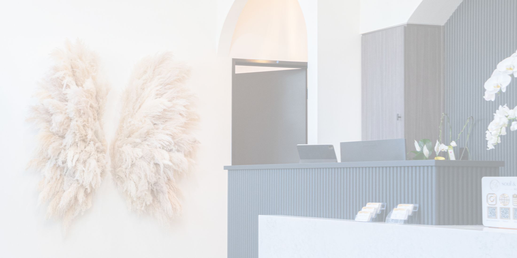 Spa reception with decorative pampas grass artwork.