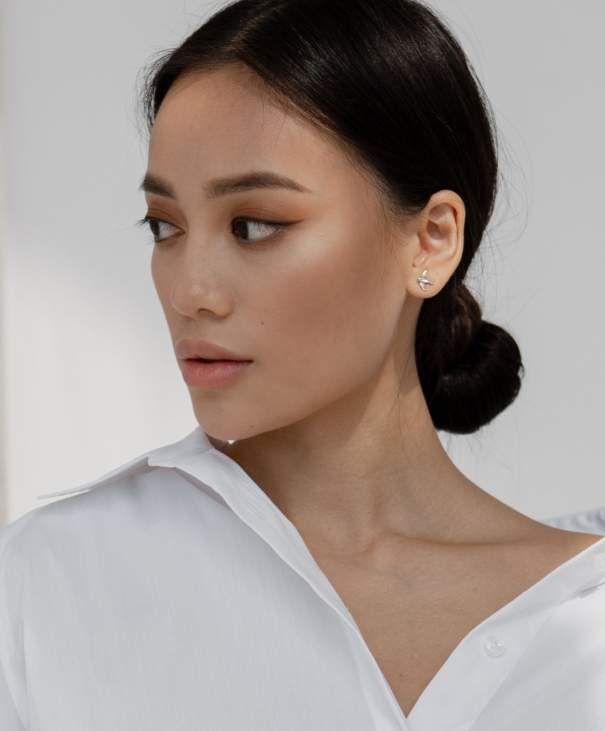 Smiling woman with long hair, hands on face.