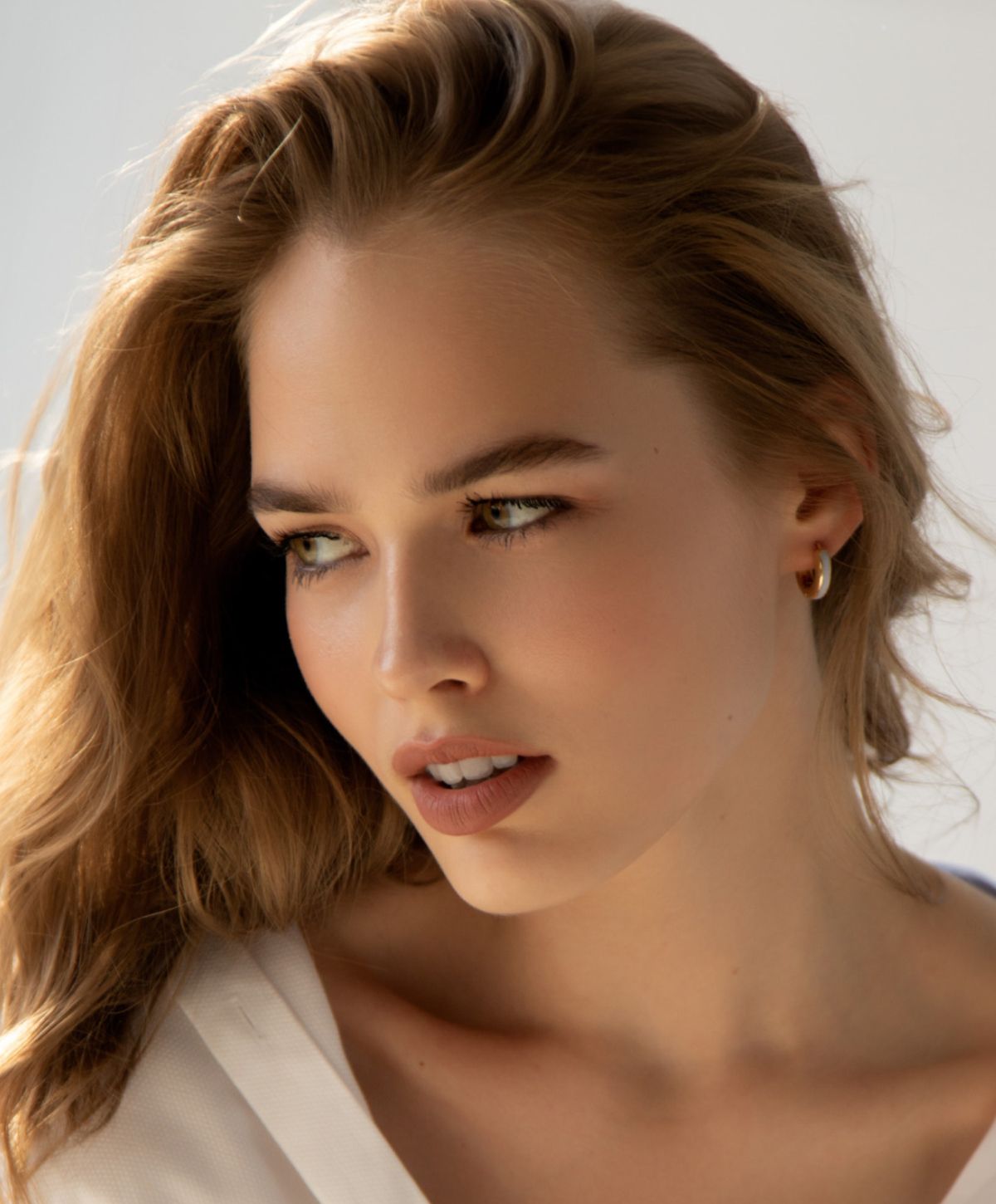 Woman with long hair posing thoughtfully indoors.