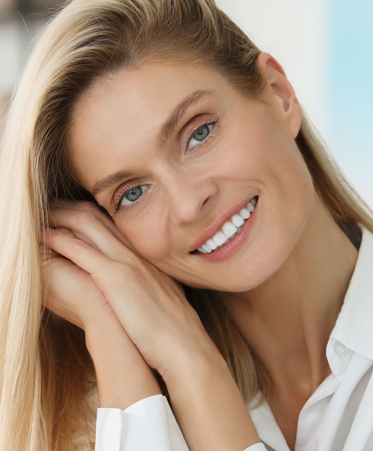 Smiling woman with long hair and light makeup.