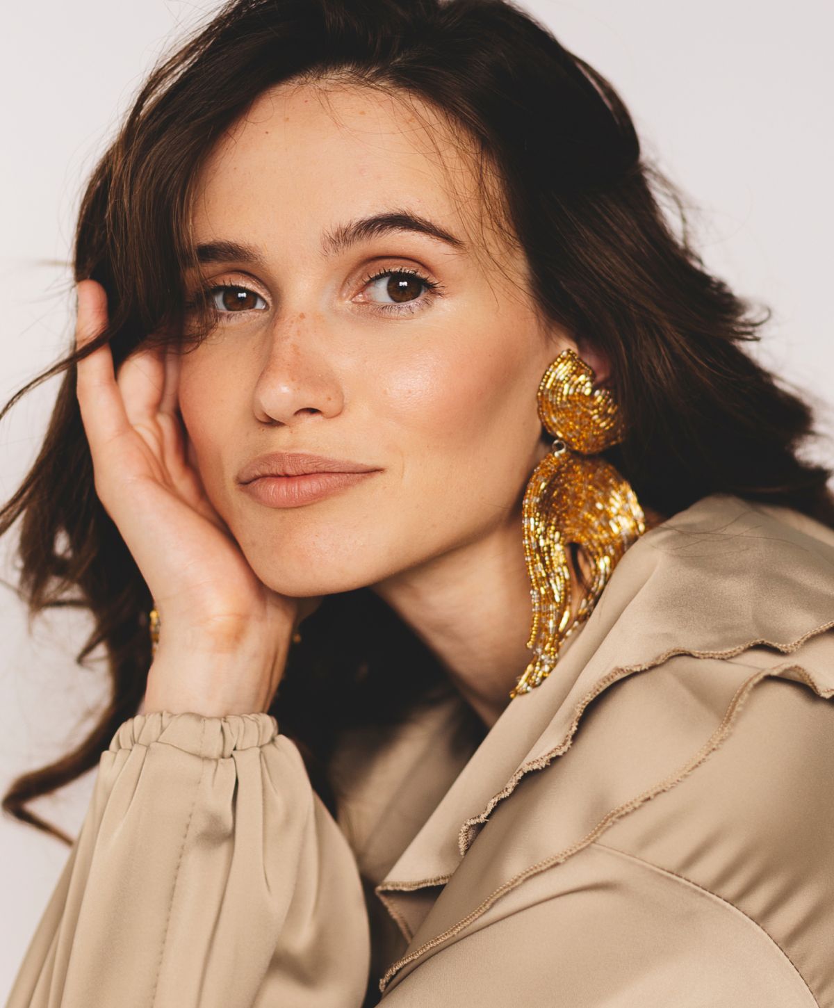 Orange County Restylane model with golden earrings and elegant blouse.