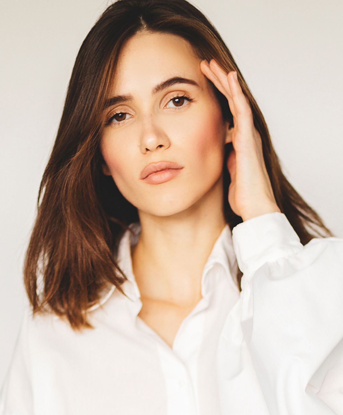 Rancho Santa Margarita med spa model in white shirt, softly posing and thoughtful.