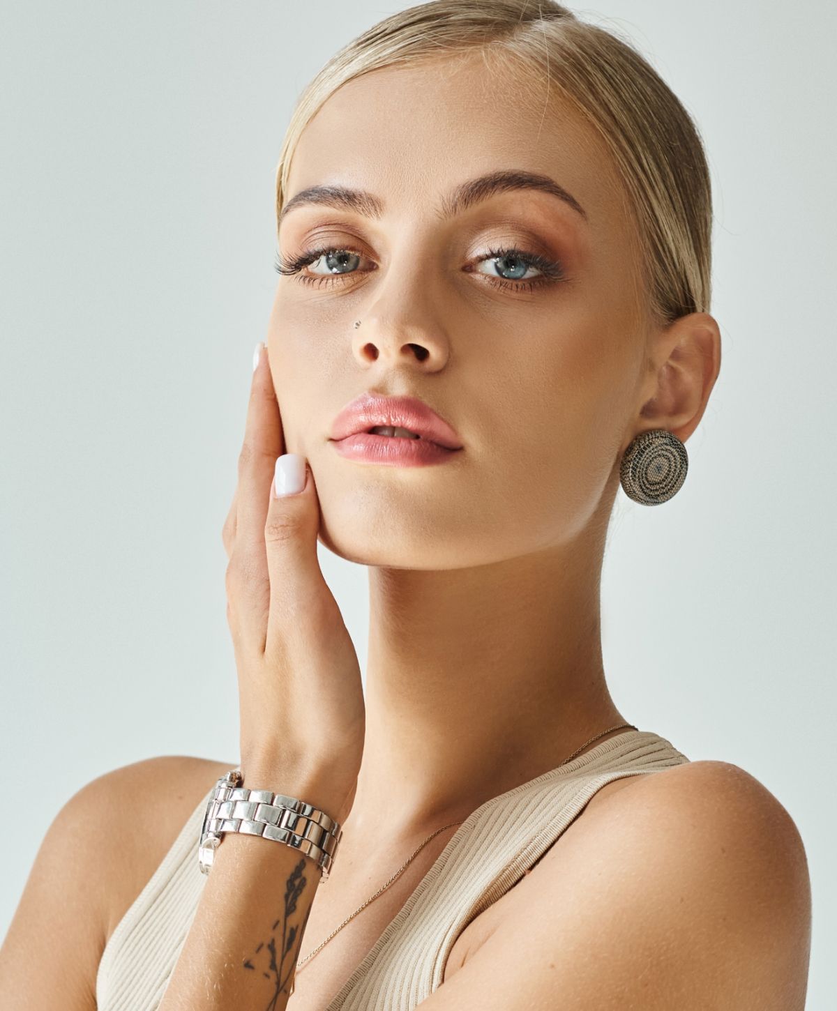 PRP injections model with stylish earrings and watch.
