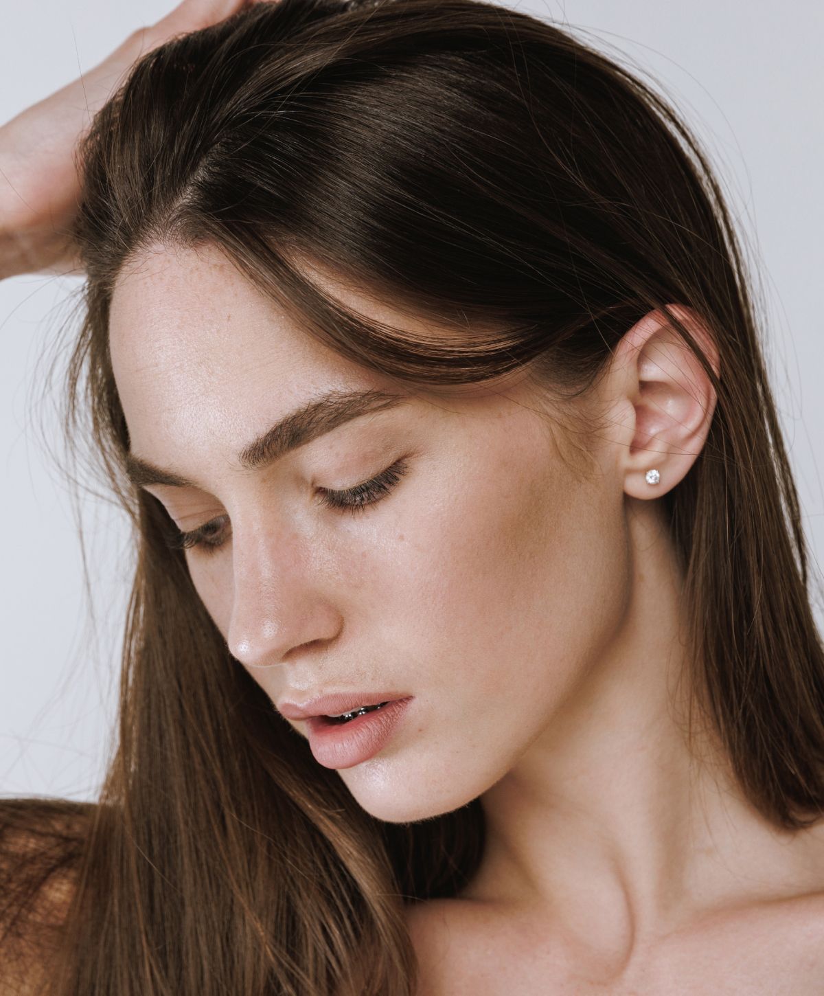 Orange County rf microneedling model with long hair and earrings.