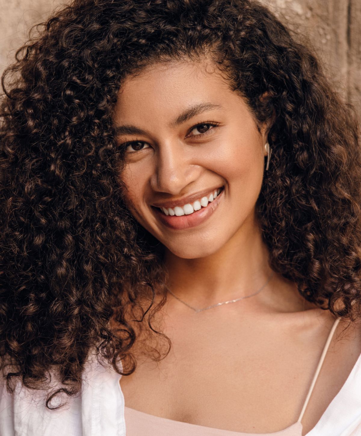 Orange County HydraFacial model with curly hair and natural makeup.