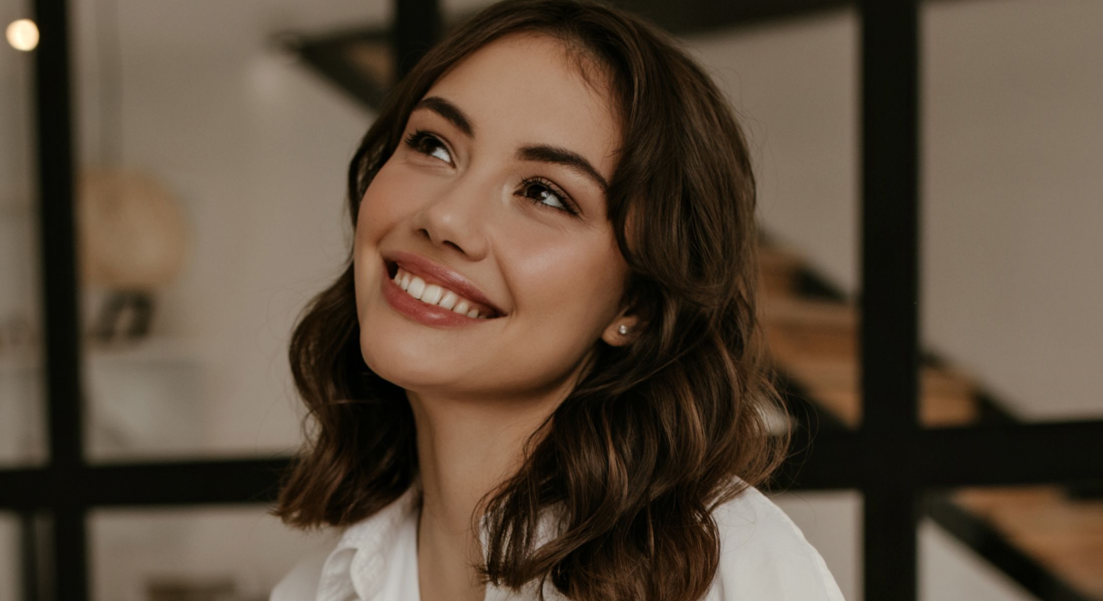 Mission Viejo TMJ treatment model with wavy hair indoors.