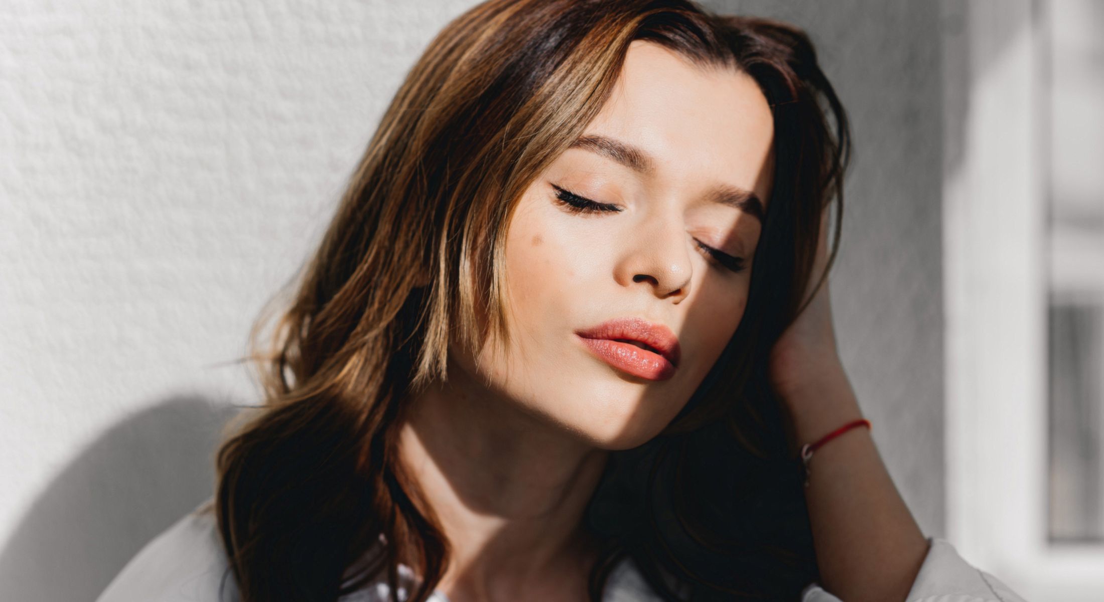 Lake Forest dermal fillers model with closed eyes in soft sunlight.