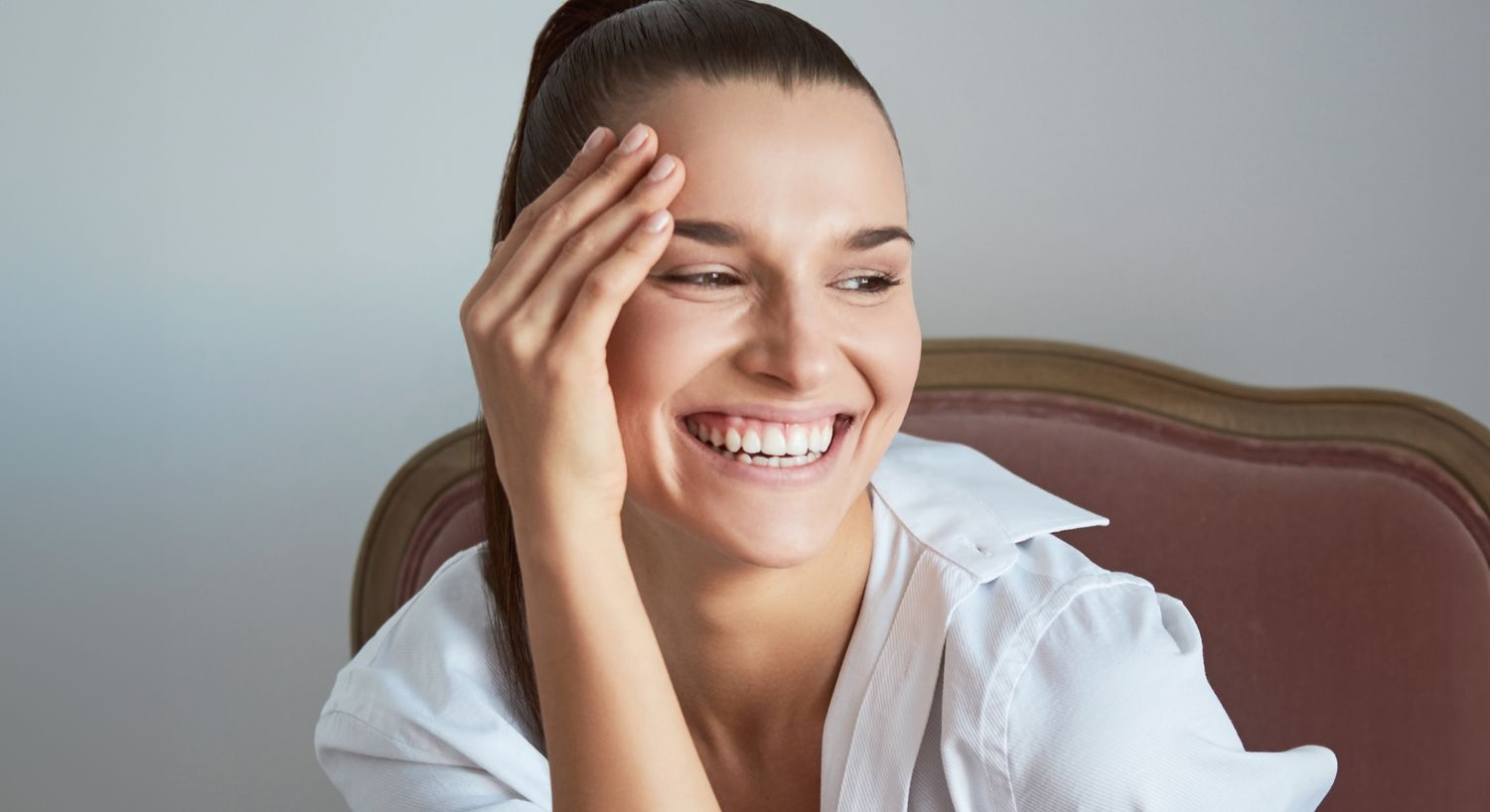 Orange County Moxi model wearing a white shirt, joyful expression.